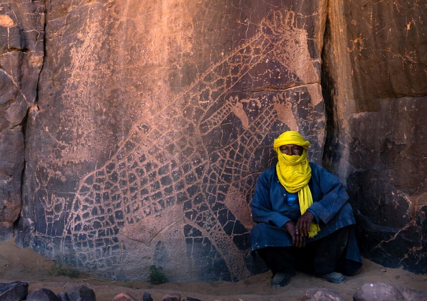 02 tuareg dekat ukiran batu yang menggambarkan jerapah taman nasional tassili n ajjer tadrart rouge
