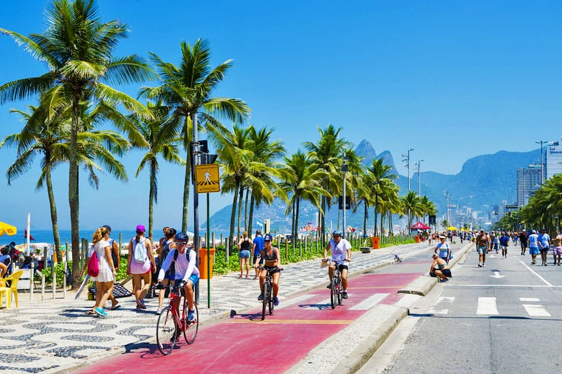 RIO DE JANEIRO - FEBRUARY 28, 2016: Active residents cycle on the bike lane next to the beachfront road Avenida Vieira Souto in Ipanema Beach, which is closed to vehicles on Sundays.