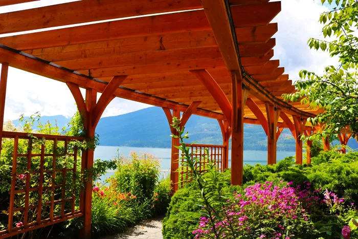 pergola lorong kayu melengkung yang dikelilingi bunga