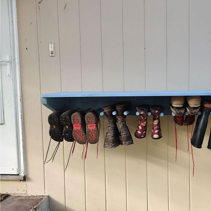 Rak dengan sepatu gantung di dekat pintu rumah