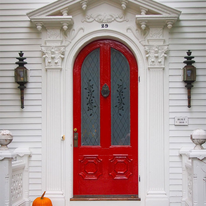 Rumah putih dengan pintu merah dan pemukul pintu