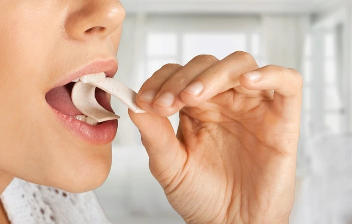 06 close up of woman putting gum in her mouth