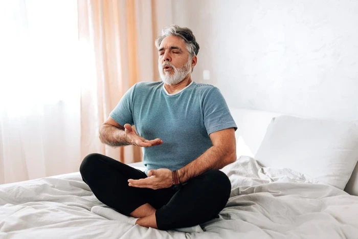 08 man practicing deep breathing in bed