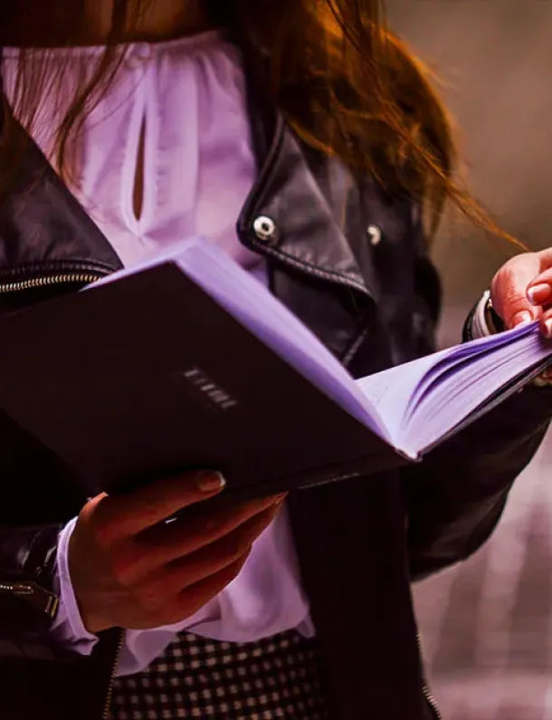 Perempuan membaca buku dengan santai