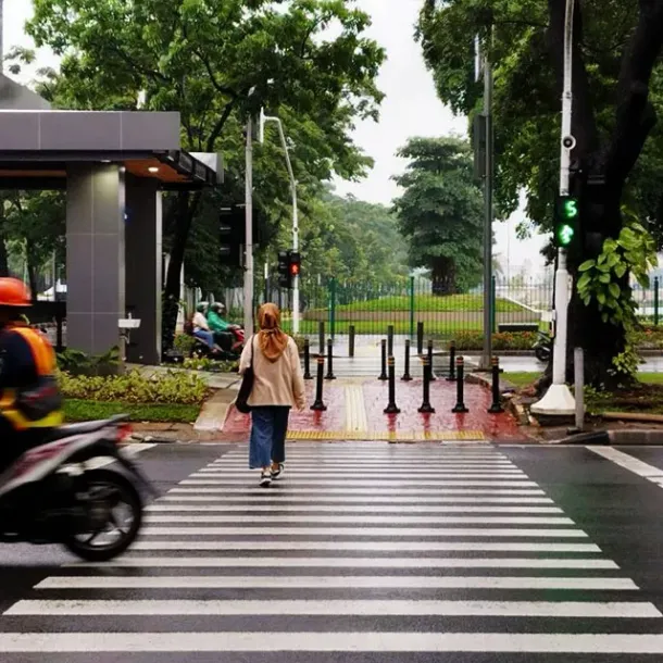 Pejalan kaki melintasi zebra cross di jalan kota Indonesia