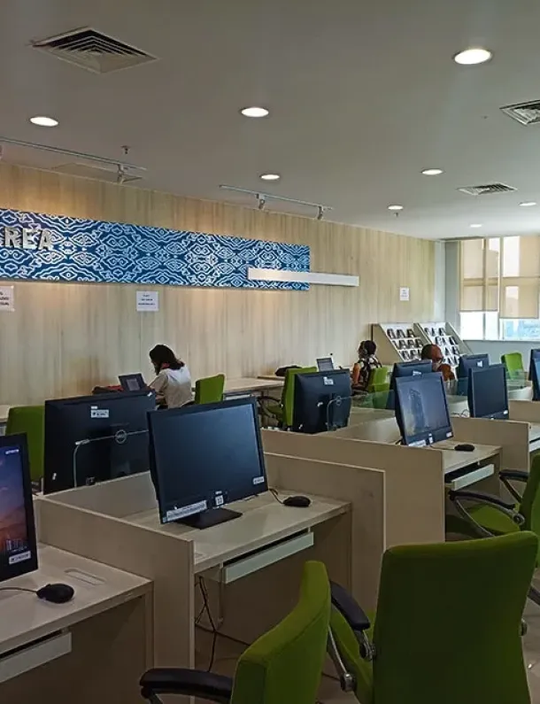 Area baca Perpustakaan Nasional RI—deretan meja, kursi, dan jendela besar yang terang