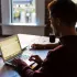 Pria bekerja fokus dengan laptop di meja kantor