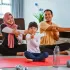 Keluarga Indonesia tersenyum bersama di ruang tamu rumah