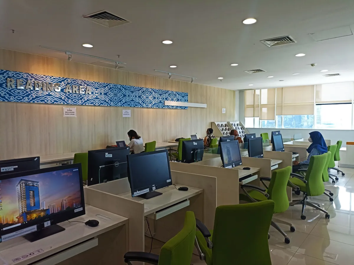 Area baca Perpustakaan Nasional RI—deretan meja, kursi, dan jendela besar yang terang