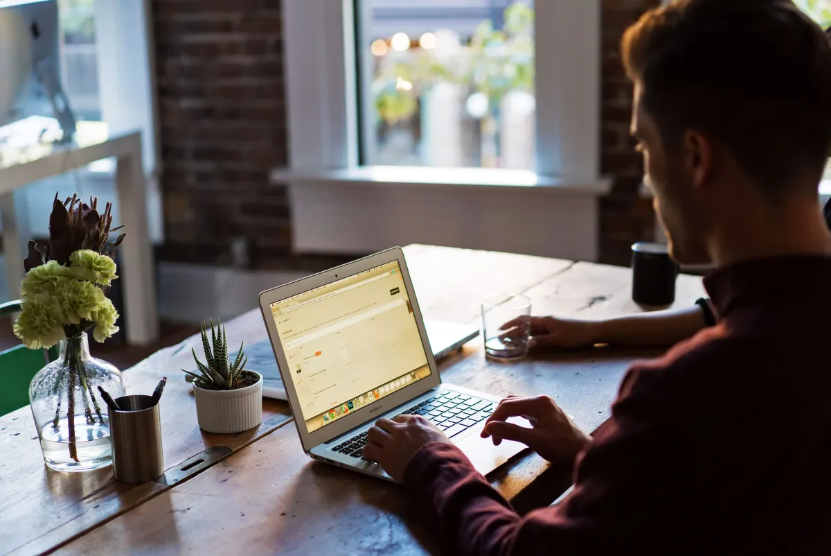 Pria bekerja fokus dengan laptop di meja kantor
